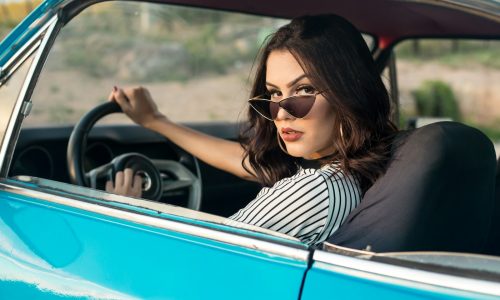 selective focus photography of woman driving blue car