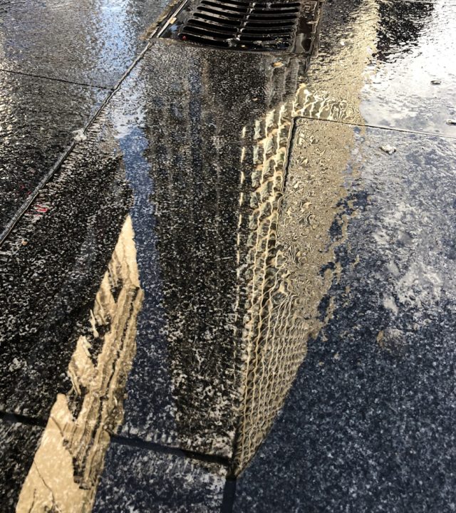 Photo by Alex Preusser a sidewalk with a puddle of water